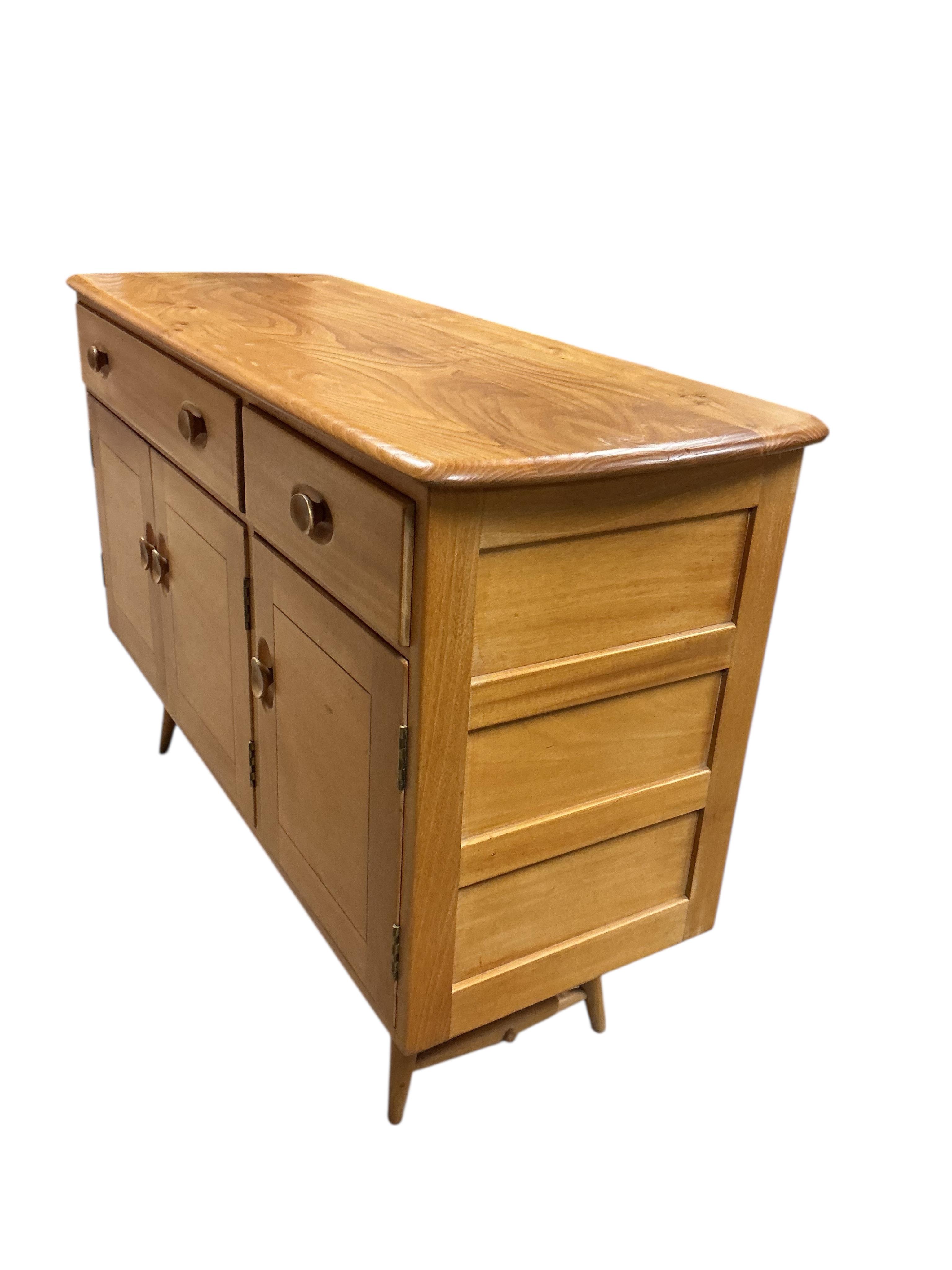 An Ercol elm and beech rectangular dining table, width 150cm, 75cm, height 72cm, together with a set of six Ercol elm and beech comb back dining chairs, two with arms and an Ercol style sideboard